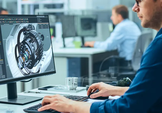 エンジニアがコンピューターで機械部品を設計しています。
